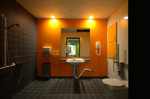 Indretning af badeværelse i orange, sorte og hvide farver på Nyt Hospital Herlev